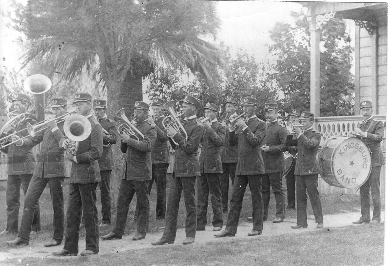 Old Band Marching in Front of Building